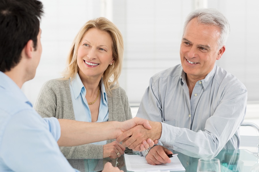 Senior Happy Couple Shaking Hand With Financial Advisor